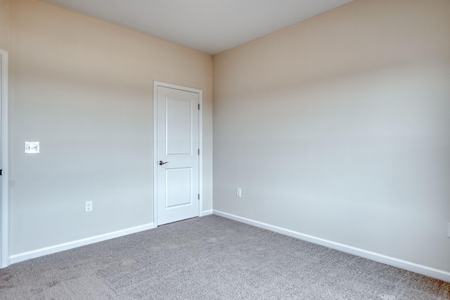 unfurnished room with carpet flooring and baseboards