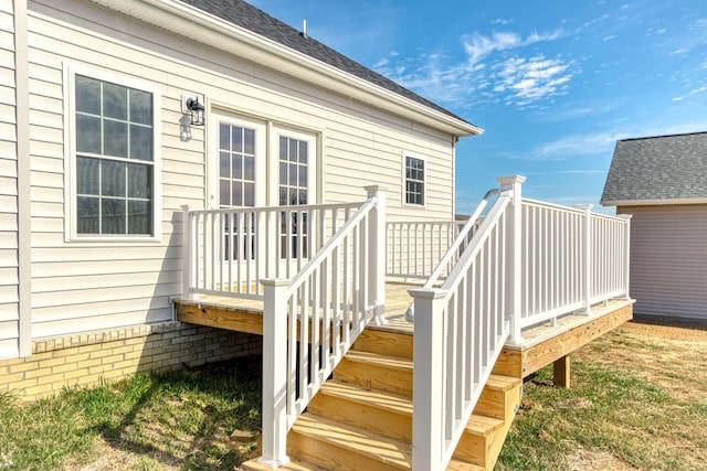 property entrance featuring a deck and a shingled roof