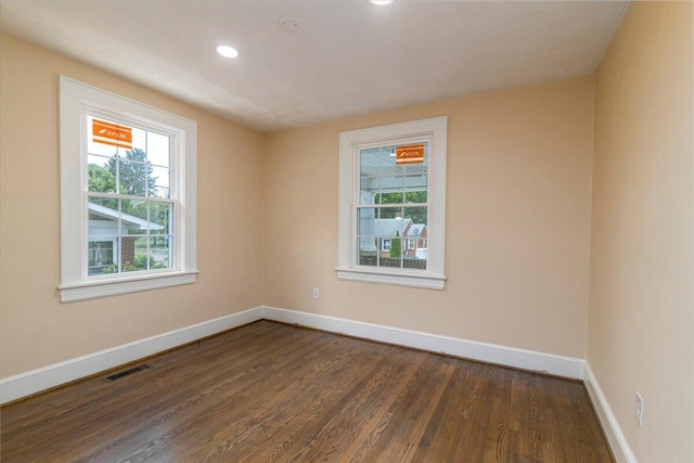 unfurnished room with dark wood-style floors, recessed lighting, visible vents, and baseboards