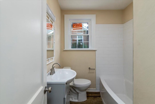 full bath with toilet, bathing tub / shower combination, wood finished floors, and vanity