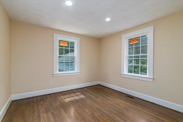 spare room with recessed lighting, dark wood-style flooring, visible vents, and baseboards