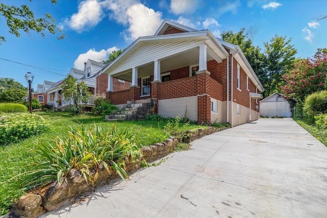 view of side of home featuring covered porch and brick siding