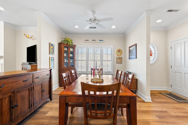 dining room featuring crown molding and light hardwood / wood-style flooring