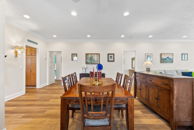 dining area featuring light hardwood / wood-style floors and crown molding