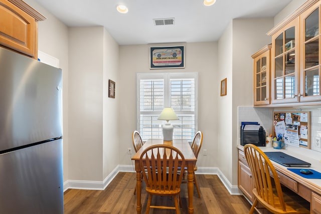 dining area featuring built in desk and dark hardwood / wood-style floors