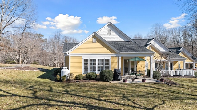 rear view of house featuring a patio area and a lawn