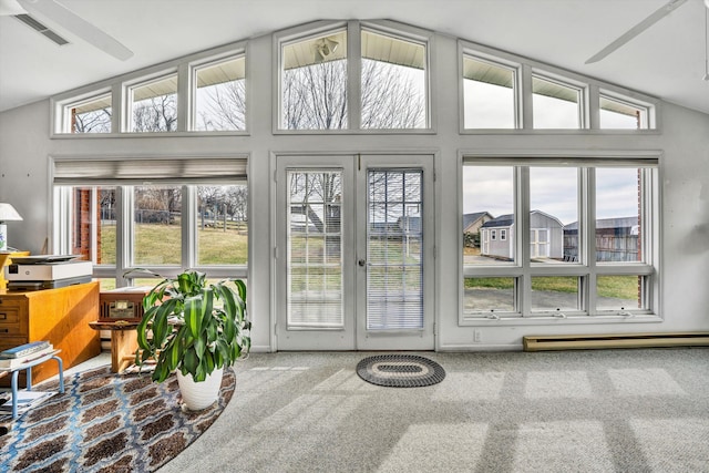 sunroom / solarium with vaulted ceiling, a healthy amount of sunlight, visible vents, and baseboard heating