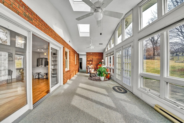 sunroom featuring a skylight, a ceiling fan, and a baseboard radiator