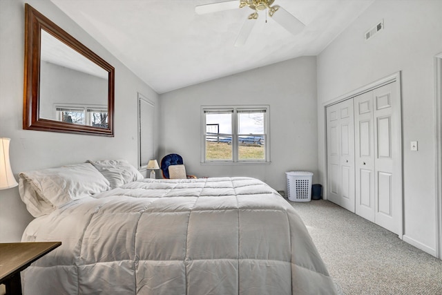 carpeted bedroom featuring visible vents, lofted ceiling, a closet, and ceiling fan