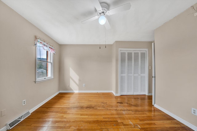 interior space featuring ceiling fan, light wood-style floors, visible vents, and baseboards