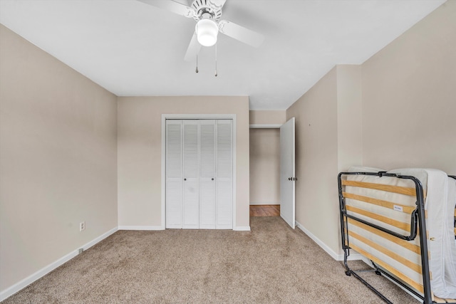 unfurnished bedroom featuring a closet, baseboards, a ceiling fan, and carpet flooring