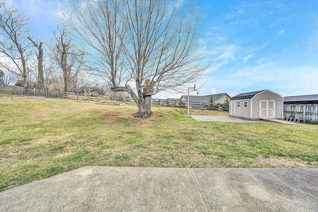 view of yard with an outbuilding, a shed, a patio area, and a fenced backyard