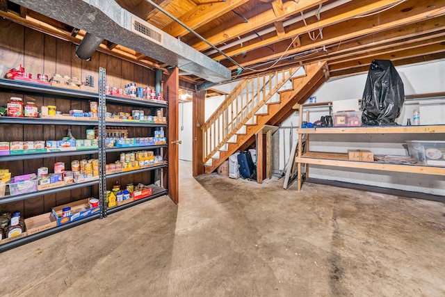 unfinished basement featuring visible vents and stairs