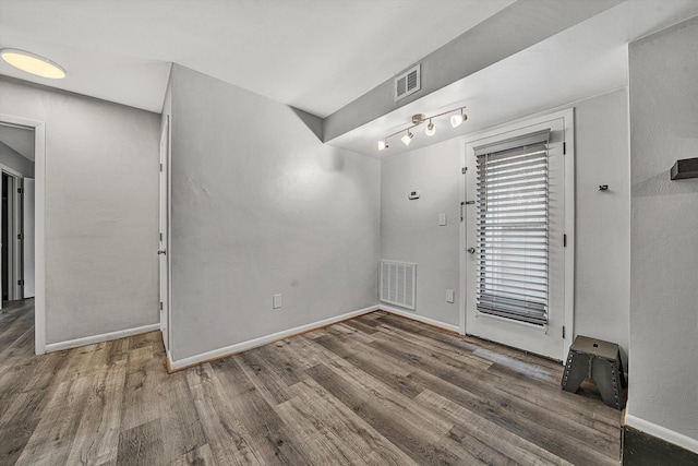 unfurnished room featuring baseboards, visible vents, and dark wood-style floors