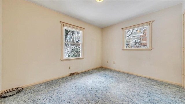 unfurnished room featuring carpet, visible vents, and baseboards