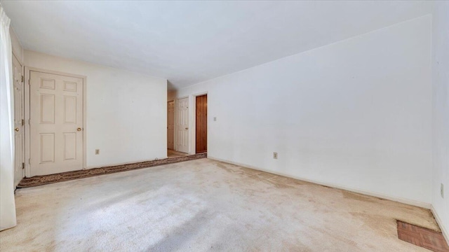 unfurnished room featuring carpet and baseboards