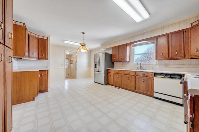 kitchen with a sink, light floors, stainless steel refrigerator with ice dispenser, and white dishwasher