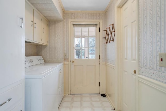 laundry room featuring light floors, wallpapered walls, cabinet space, ornamental molding, and washer and clothes dryer