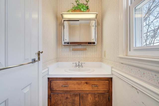 bathroom with wallpapered walls and vanity