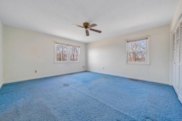 empty room featuring a healthy amount of sunlight, baseboards, and carpet floors