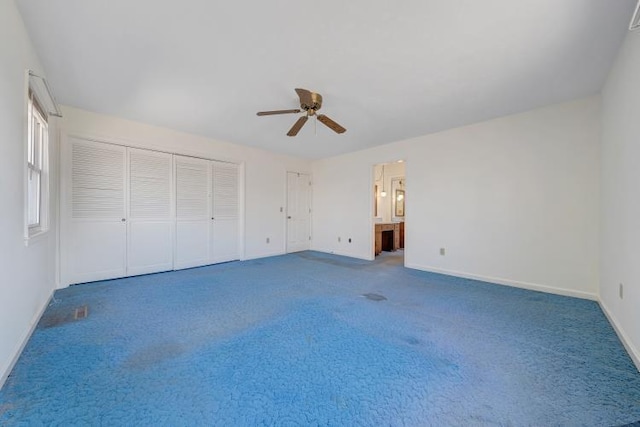 unfurnished bedroom featuring a closet, baseboards, carpet floors, and ceiling fan