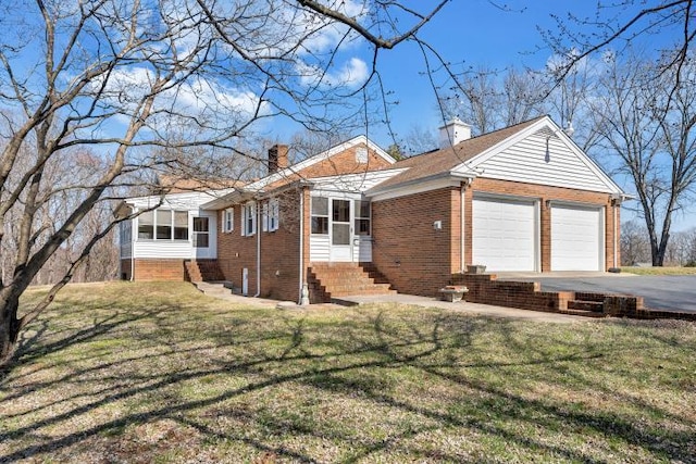 view of front facade featuring driveway, an attached garage, a chimney, entry steps, and brick siding