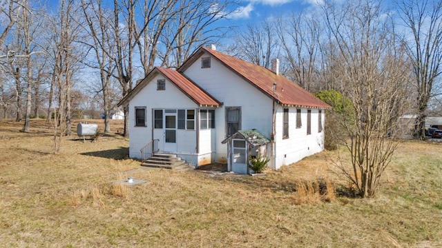 view of front facade with crawl space, metal roof, a front lawn, and entry steps