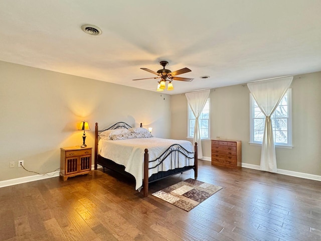 bedroom with ceiling fan, baseboards, visible vents, and dark wood finished floors