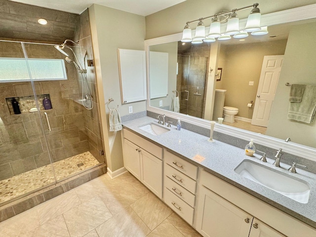 full bathroom with double vanity, a sink, toilet, and a shower stall