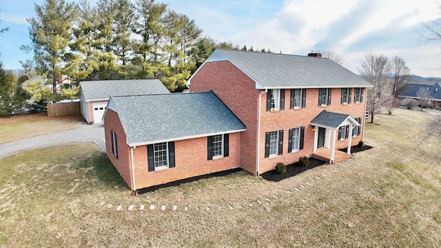 rear view of house featuring roof with shingles, a lawn, a chimney, and brick siding