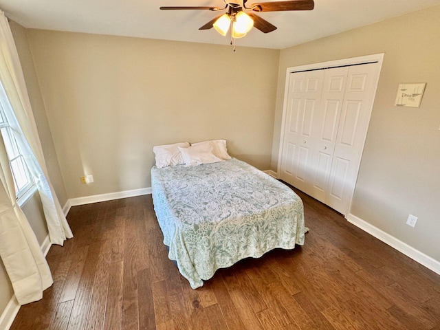 bedroom with a closet, dark wood-style flooring, baseboards, and a ceiling fan