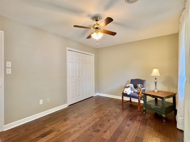 living area with dark wood-style floors, baseboards, and a ceiling fan