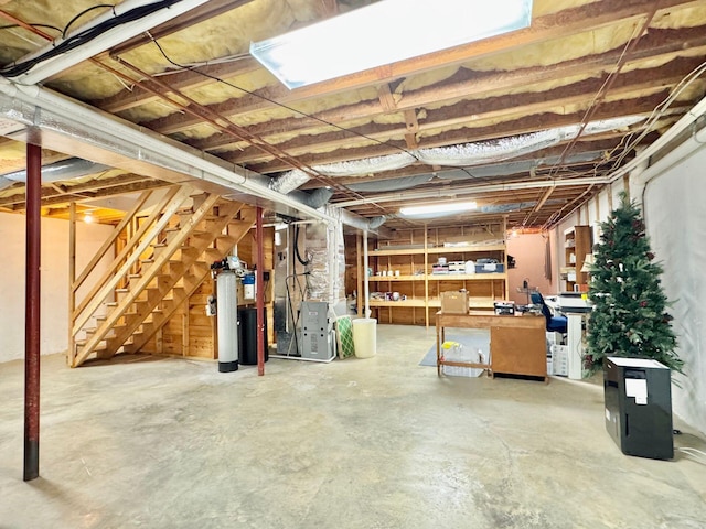 unfinished basement with heating unit and stairs