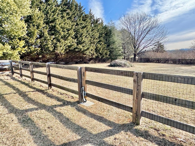 view of gate with a rural view and fence