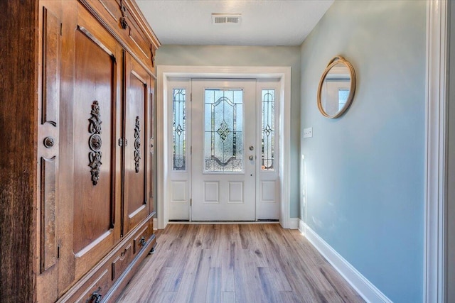 foyer entrance featuring light wood-style flooring, visible vents, and baseboards