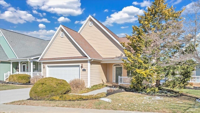 view of front of property with a porch, a shingled roof, driveway, and a garage