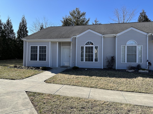 ranch-style house featuring a front yard and a shingled roof