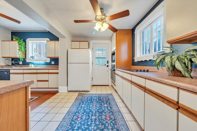 kitchen featuring a wealth of natural light, light tile patterned flooring, and black appliances