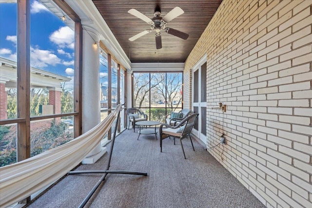 unfurnished sunroom with wood ceiling and ceiling fan