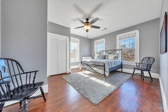 bedroom with dark wood-type flooring, multiple windows, and visible vents