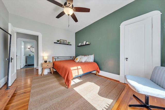 bedroom featuring a ceiling fan, baseboards, and wood finished floors