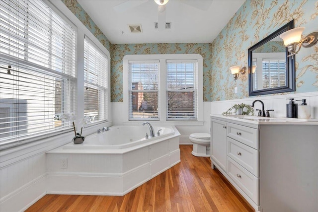 full bath with wainscoting, visible vents, and wallpapered walls