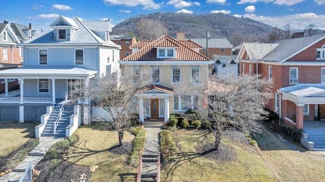 view of front of house featuring a residential view, a mountain view, and a front lawn