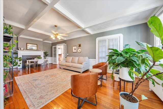 living area featuring hardwood / wood-style floors, coffered ceiling, a fireplace, and beam ceiling