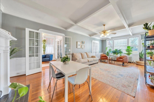 interior space with radiator, hardwood / wood-style flooring, coffered ceiling, and beamed ceiling