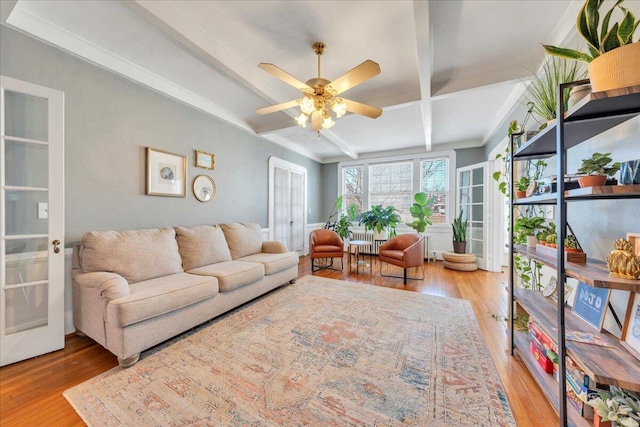 living room with coffered ceiling, wood finished floors, beam ceiling, and a ceiling fan