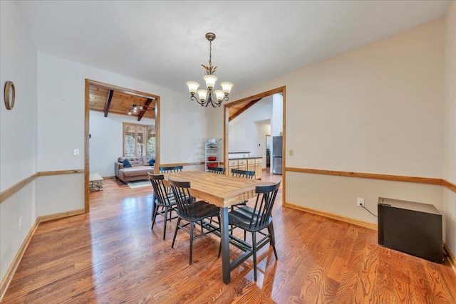 181 Borderline Rd NW, Willis, VA 24380 - dining space featuring an inviting chandelier, wood finished floors, baseboards, and beam ceiling