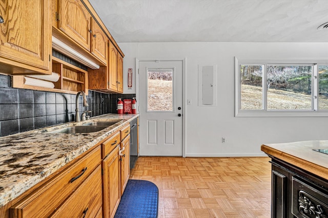 kitchen featuring decorative backsplash, a wealth of natural light, dishwasher, and a sink