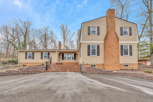 view of front of property featuring a chimney and a gambrel roof