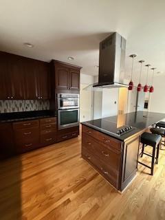 kitchen featuring light wood-type flooring, dark countertops, and appliances with stainless steel finishes
